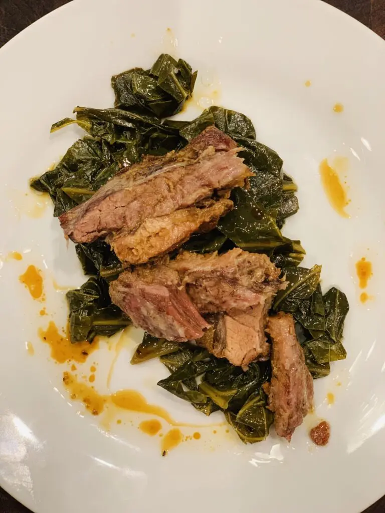 Dark, syrupy collard greens and thick, caramelized chunks of slow-roasted pork belly bubbling in a cast-iron Dutch oven