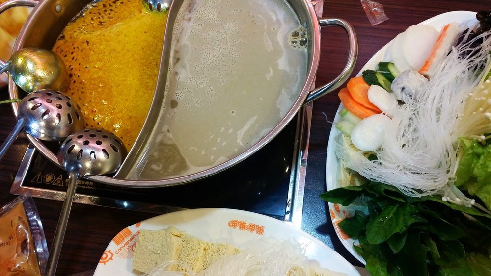 A traditional Chinese Hot Pot table spread with various meats and vegetables