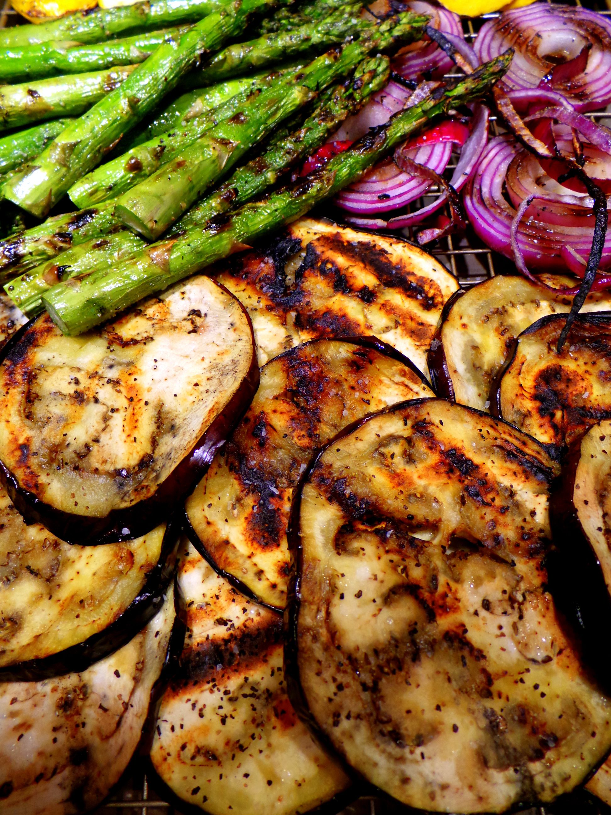 Thick cuts of summer vegetables roasting over an open flame.