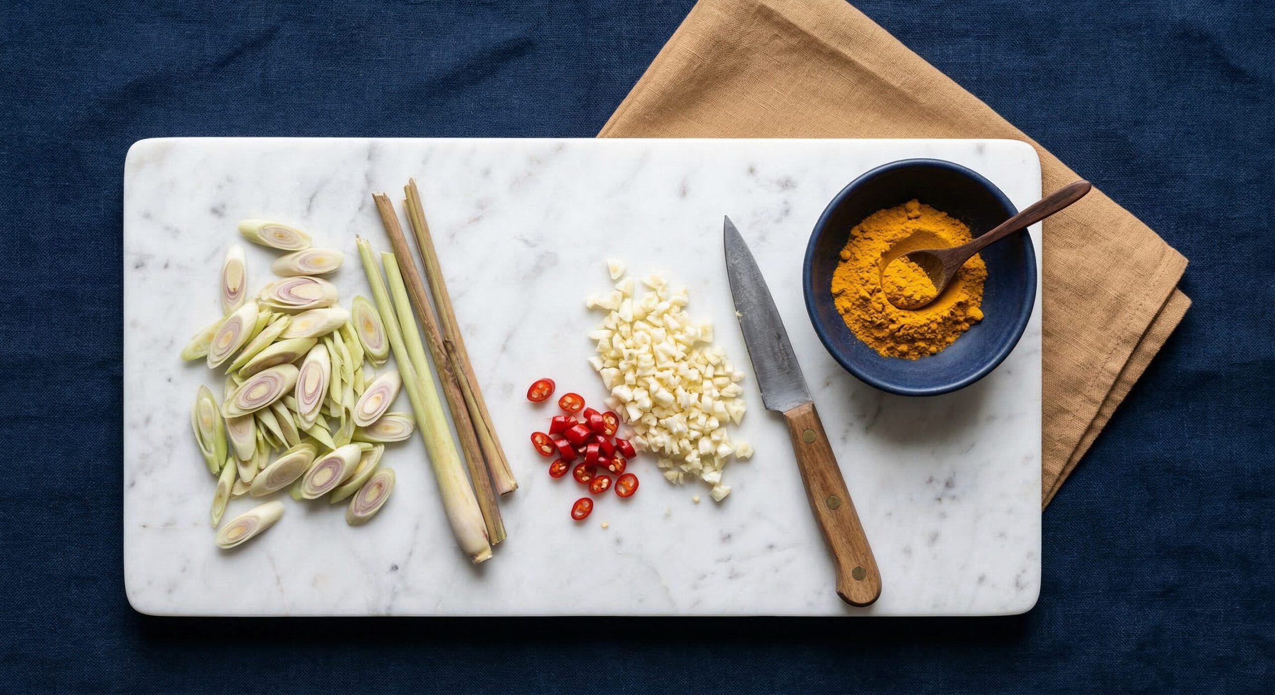 Lemongrass, garlic, turmeric, eggplant, and tomatoes arranged for a Vietnamese stew