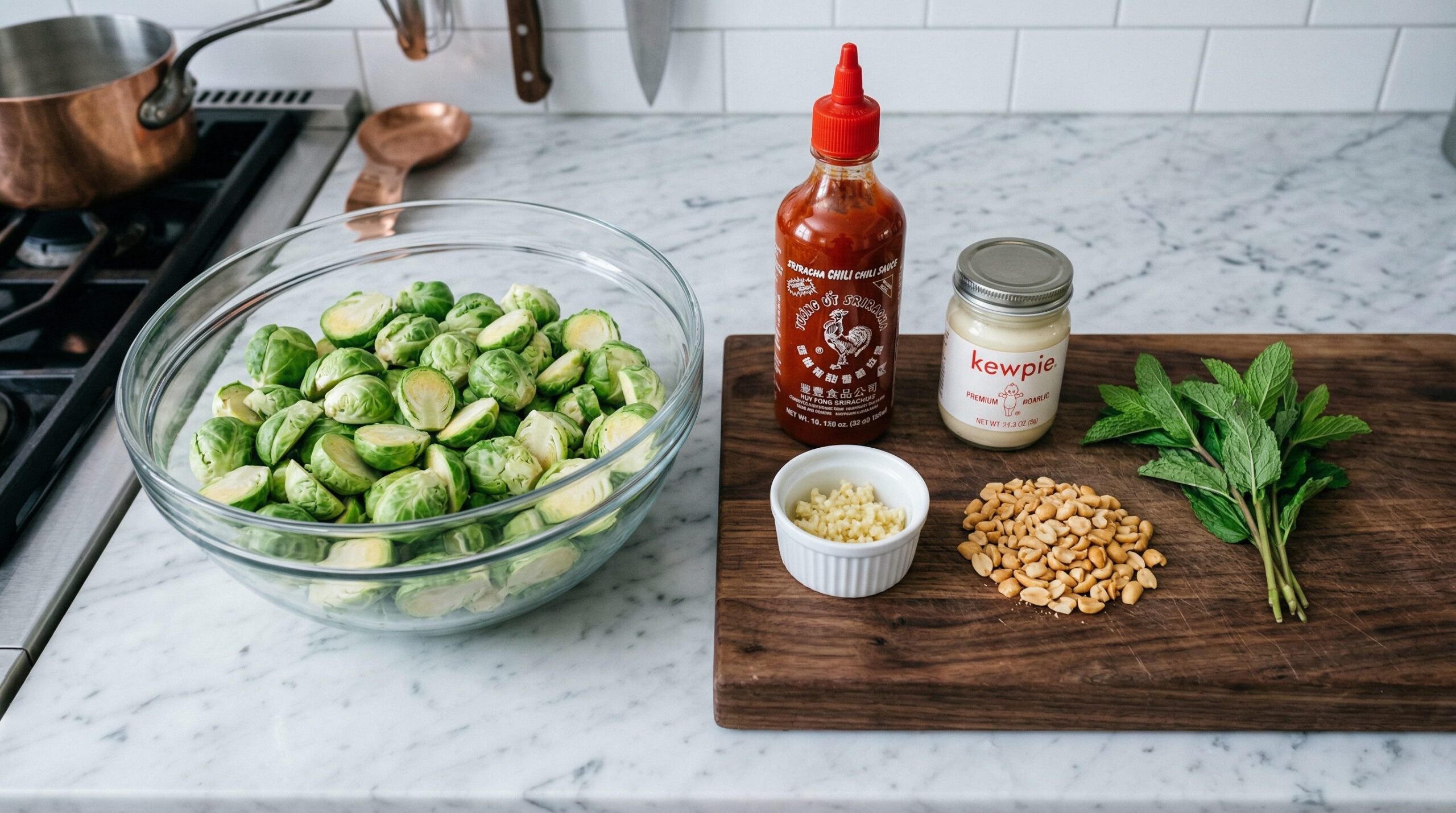 Halved Brussels sprouts being blanched before roasting, beside sriracha aioli ingredients